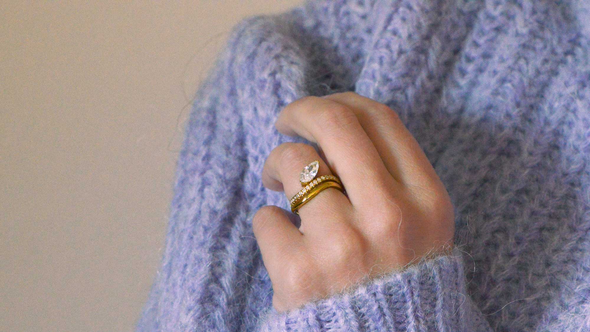 Marquise Cut diamond and gold Engagement Ring worn on the hand with a fluffy purple jumper