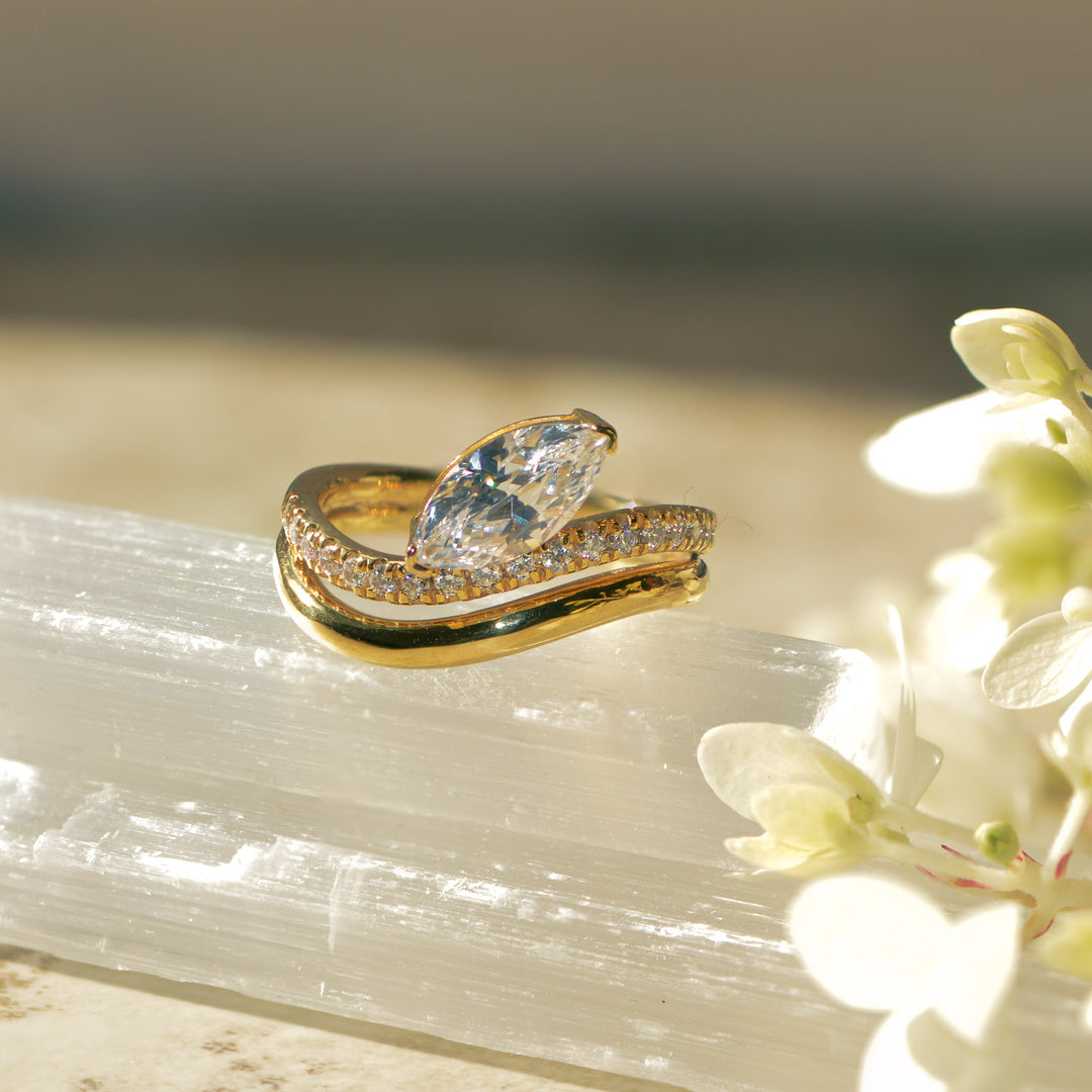 Gold engagement ring with a large diamond on a crystal and flower background