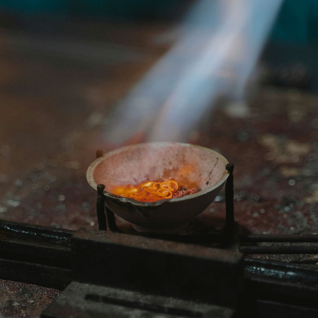 Close up of gold scrap being melted down to be reused as recycled gold grain.
