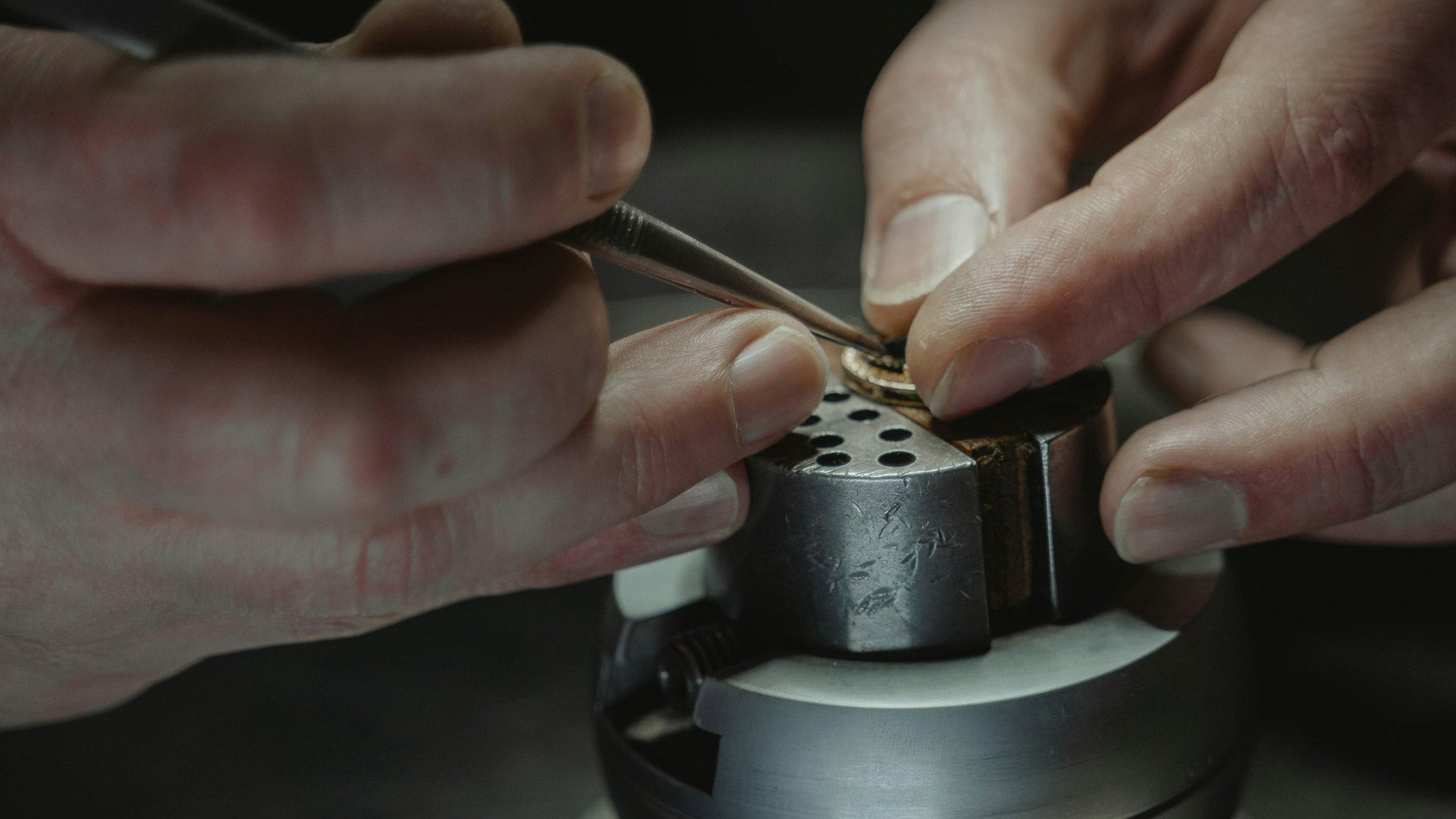 Close-up of hands using a tool on a piece of jewellery
