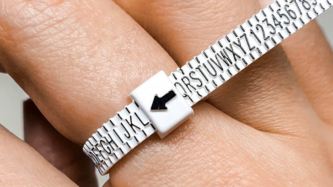 Close up of a multi size ring sizer on a person's finger to help figure out their ring size