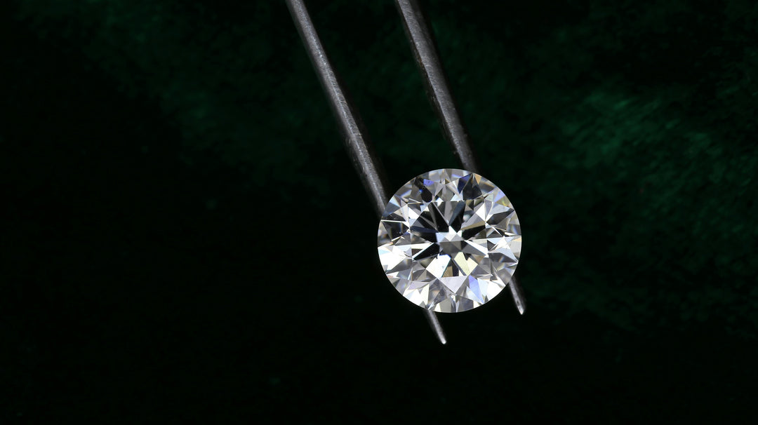 Round brilliant cut diamond under inspection with black background