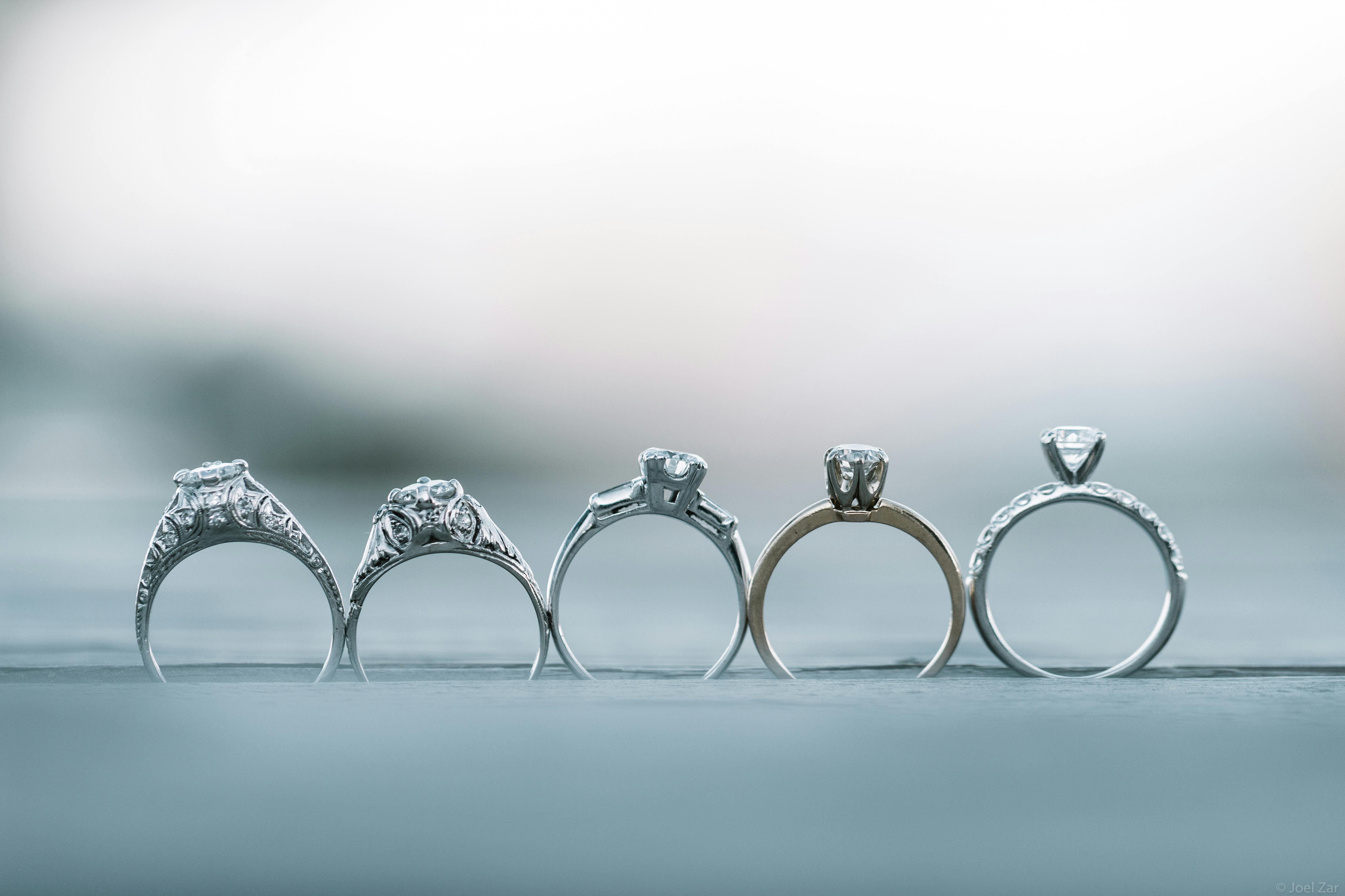 A line up of five different styles of diamond engagement ring, shown from side angle