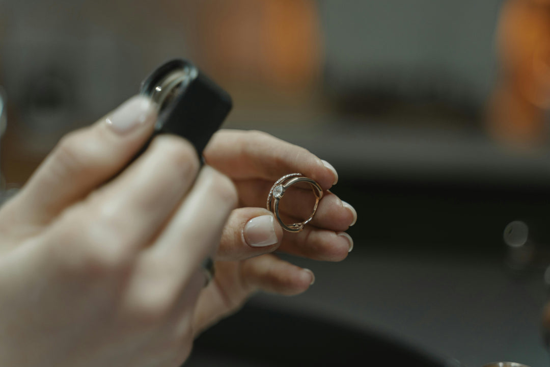 Two rings being held and inspected under a jeweller's loupe 