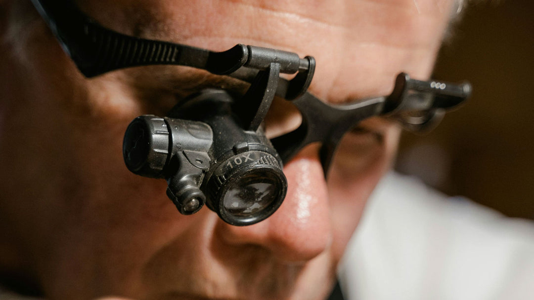 Pesron inspecting a piece of jewellery through a loupe