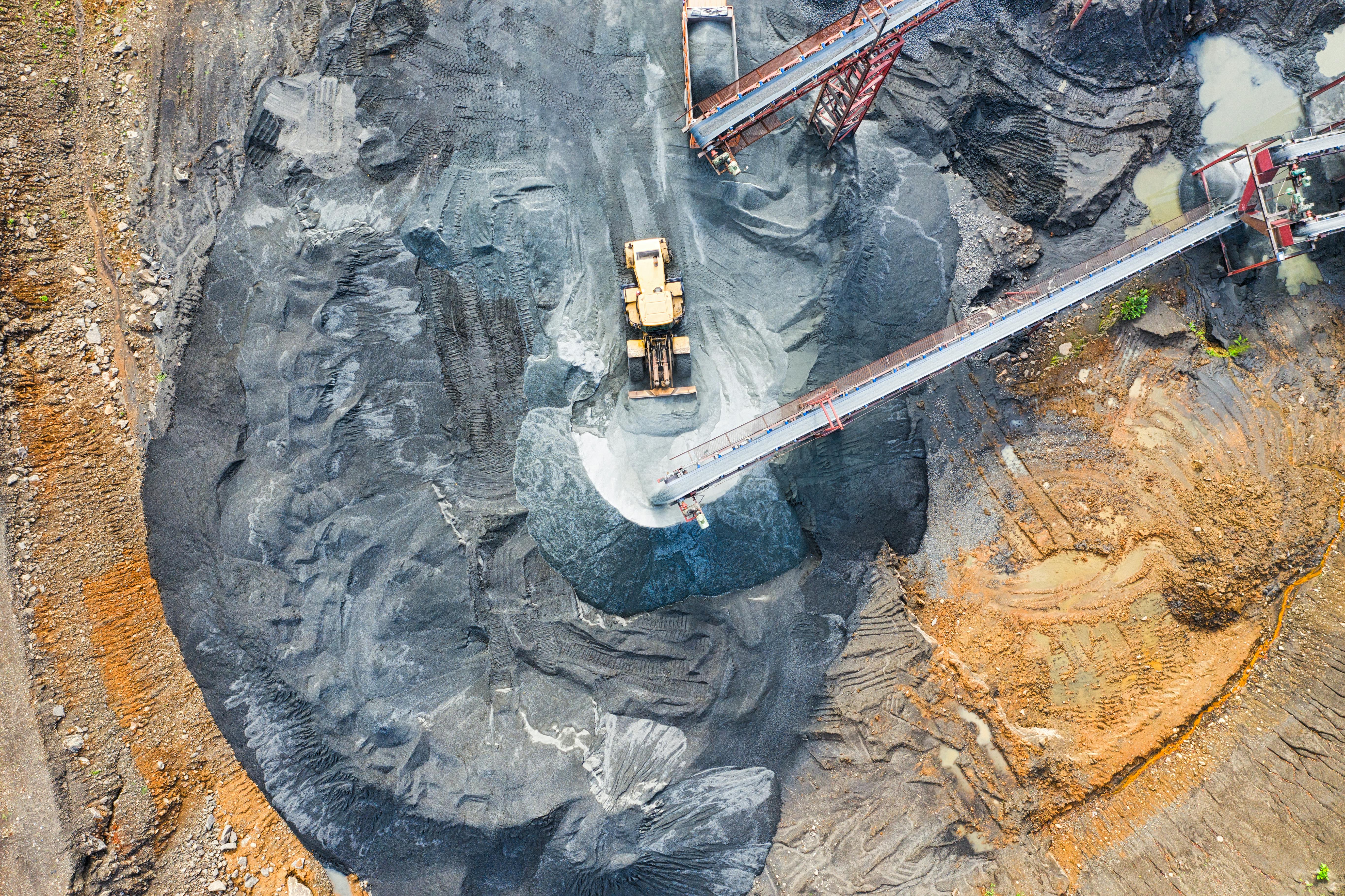 Picture of birds-eye view of mining. Showing rubble and disturbed earth amongst the machinery.