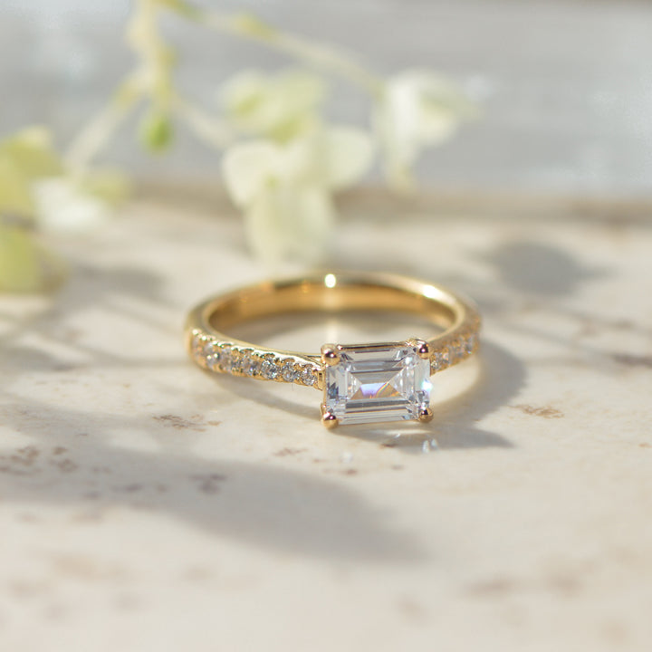 Gold engagement ring with a large diamond on a marble surface