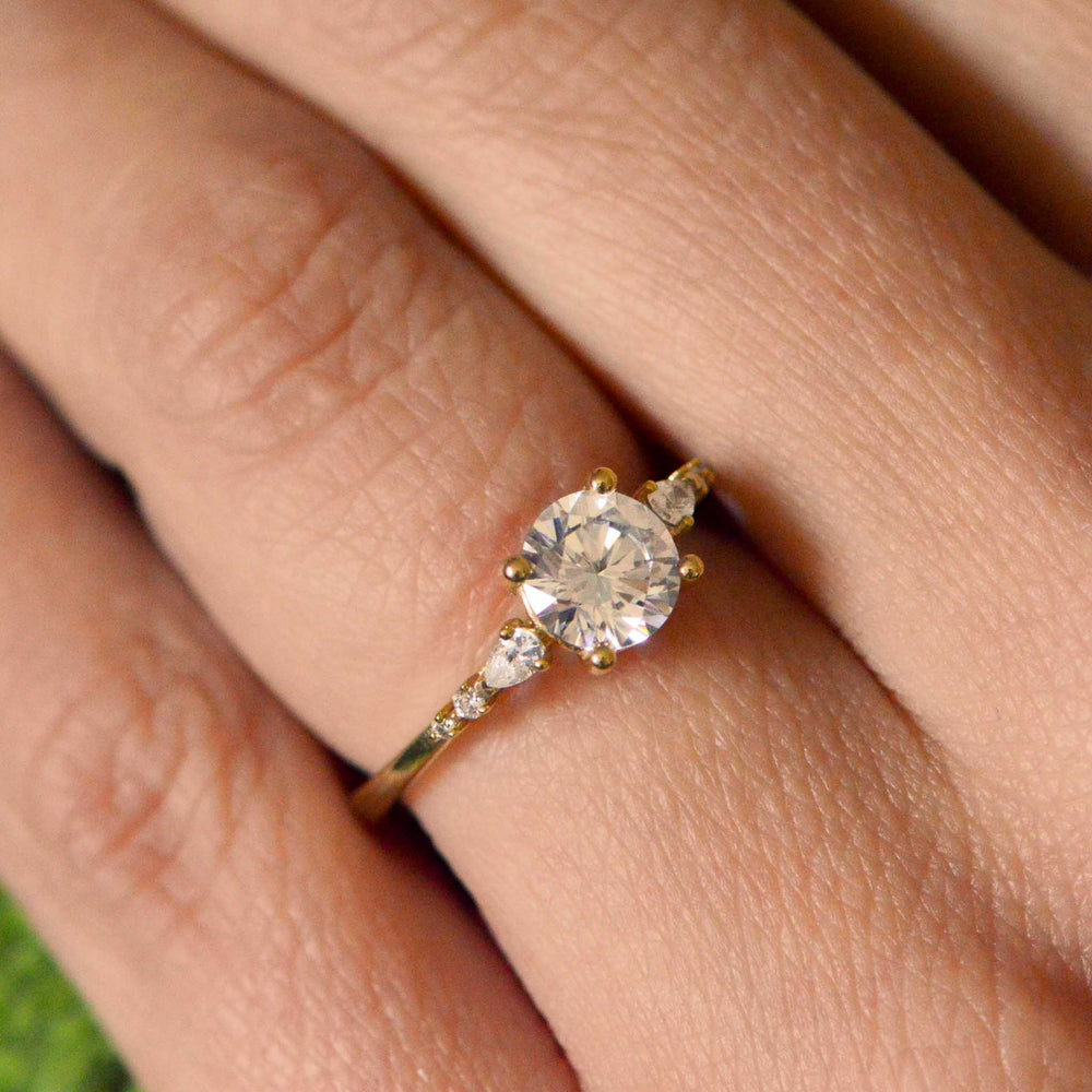 Gold ring with a large diamond on a person's finger