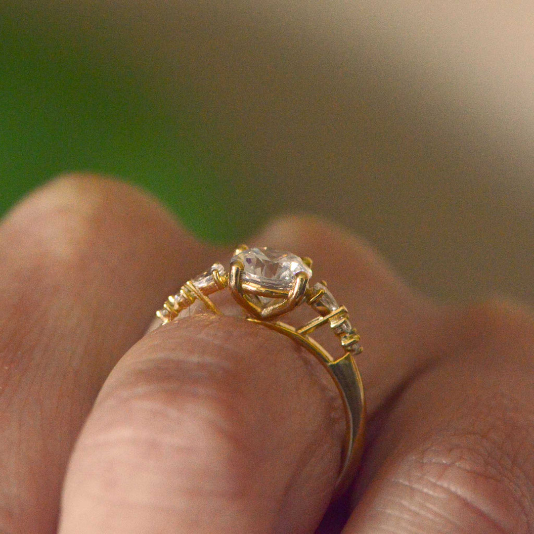 Gold ring with a diamond on a finger against a blurred background