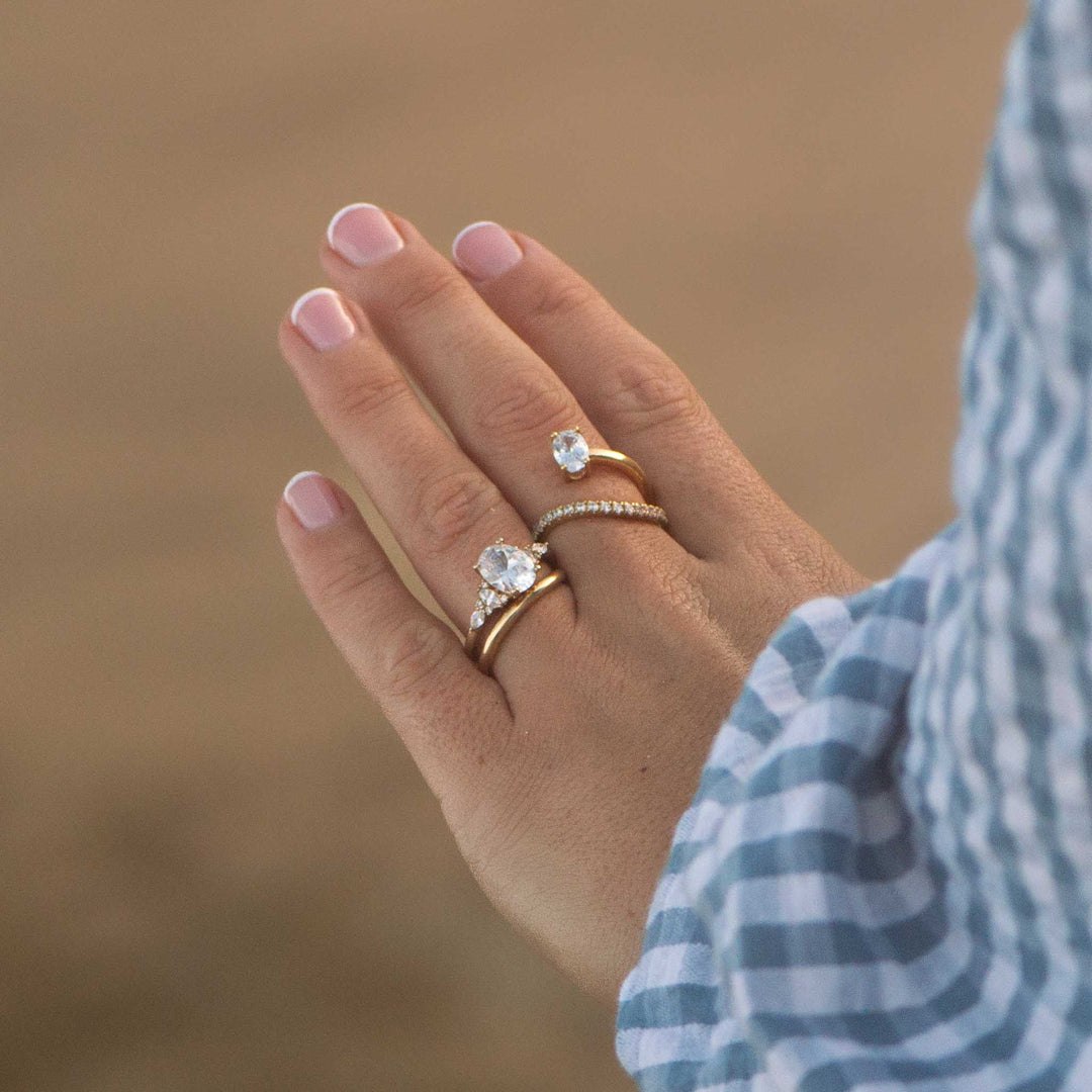 Hand wearing two diamond rings with a blurred background