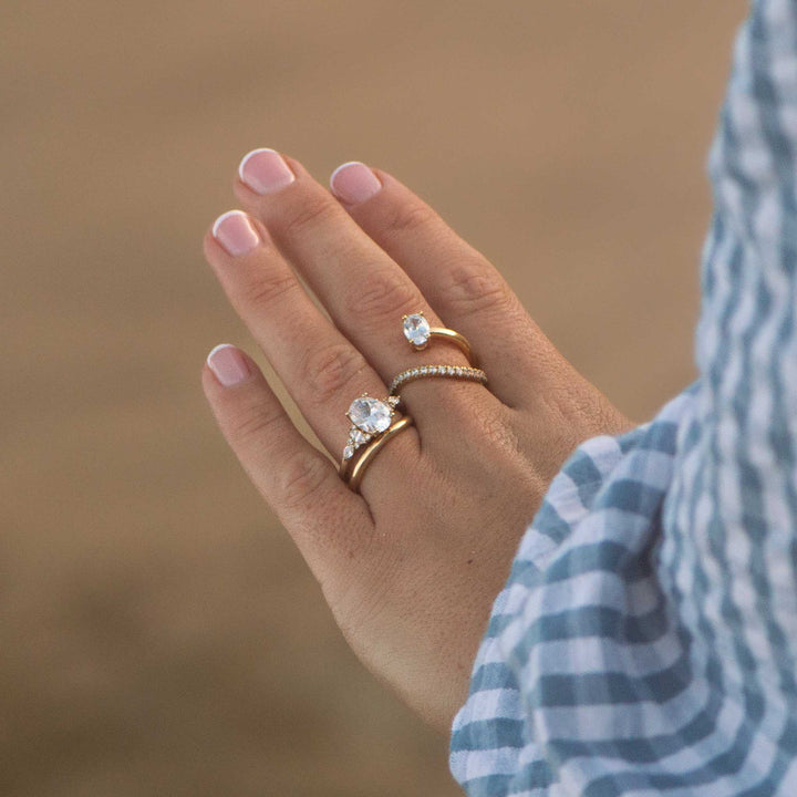 Hand wearing two diamond rings with a blurred background