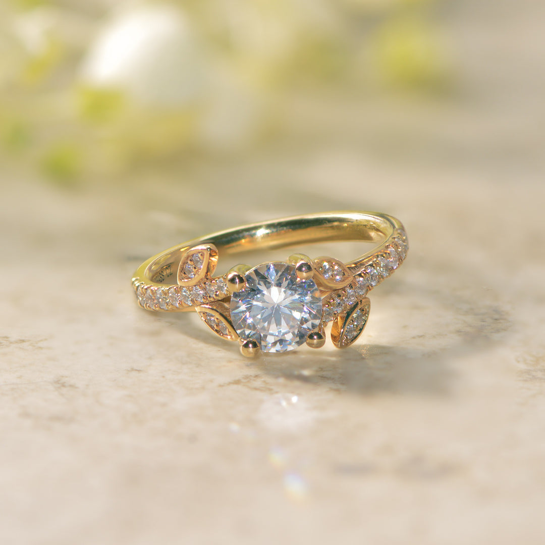 Gold vine ring with a diamond on a marble surface