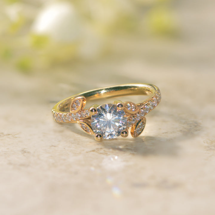 Gold vine ring with a diamond on a marble surface
