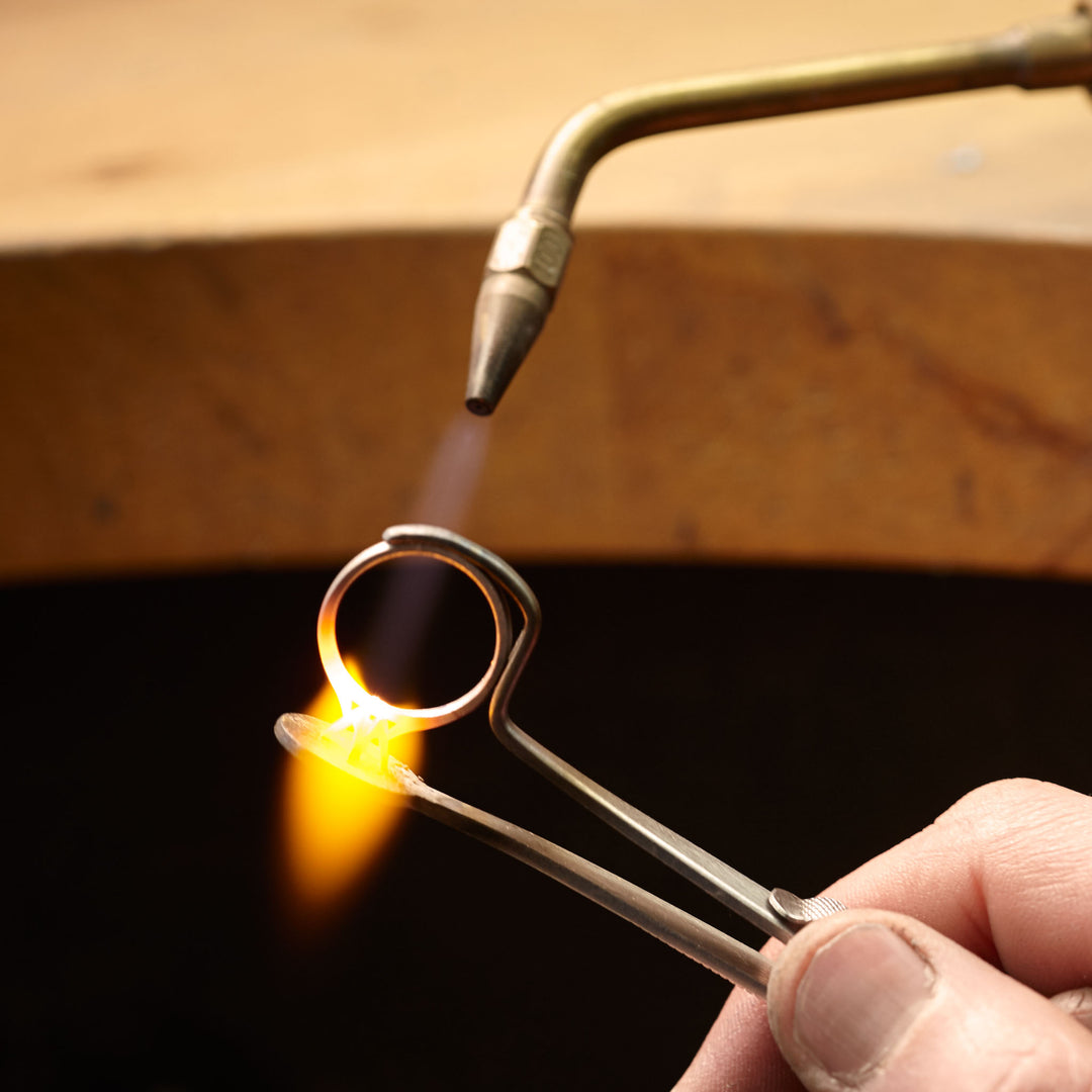 Behind the scenes of a jeweller working on mounting the setting of a custom engagement ring. 