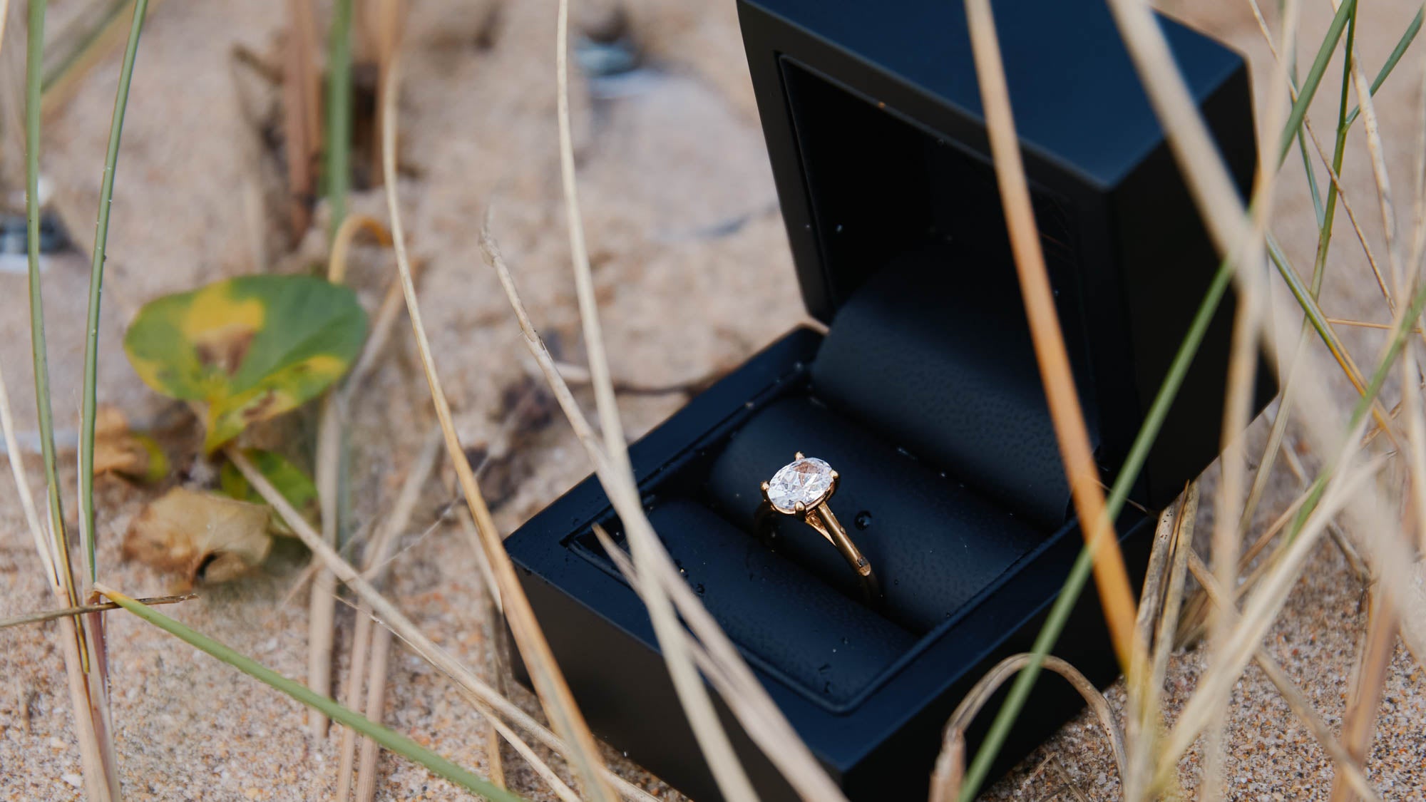 Oval diamond ring on the beach for a holiday proposal 