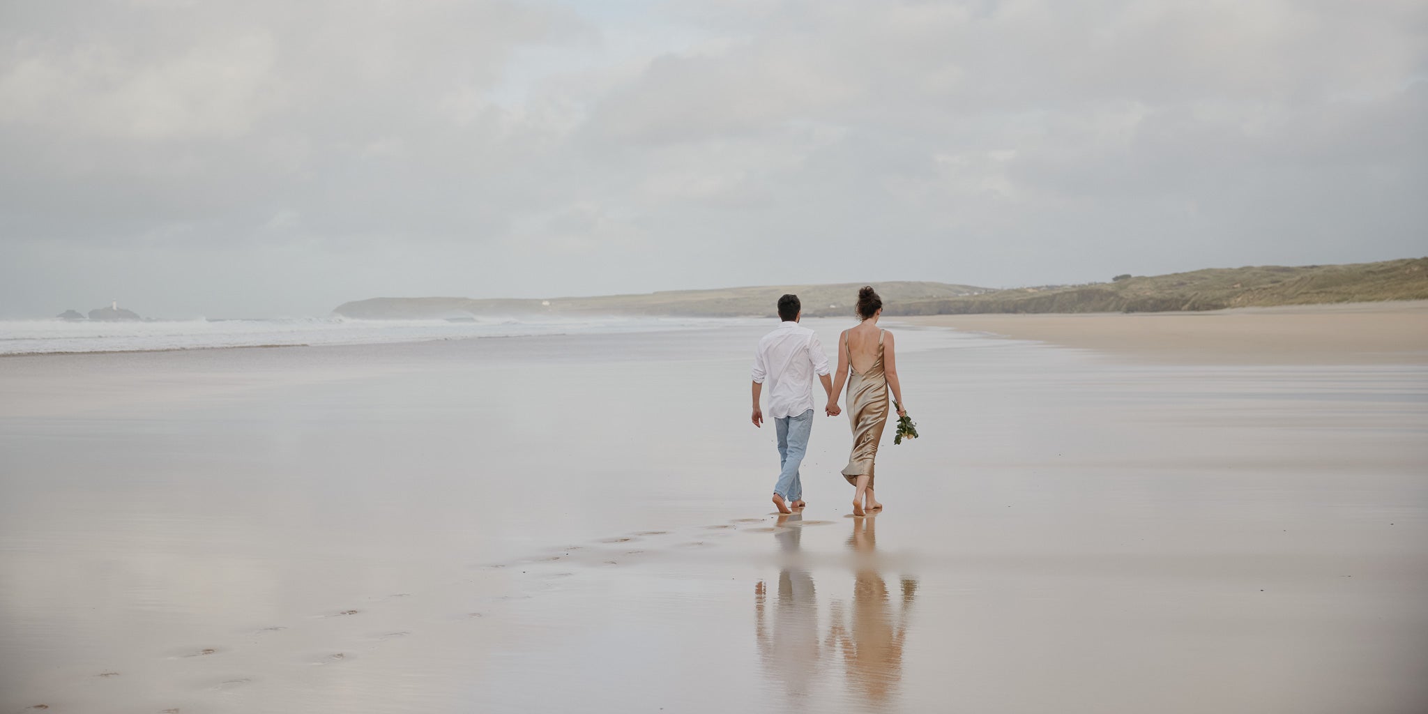 Two people walking on a beach together