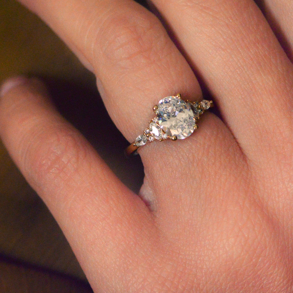 Close-up of a hand wearing a diamond ring with a blurred background