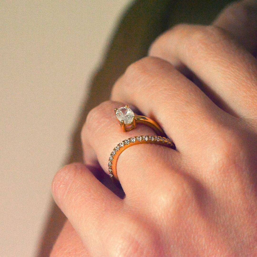 Birds Eye view of an oval cut engagement ring with a diamond pavé set band, worn on the hand