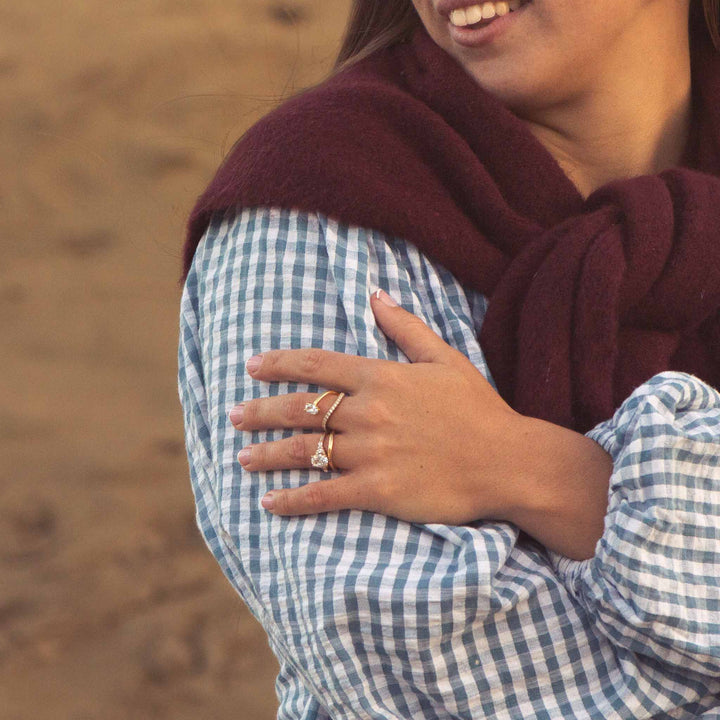 Person wearing a maroon scarf and blue checkered shirt with a blurred background