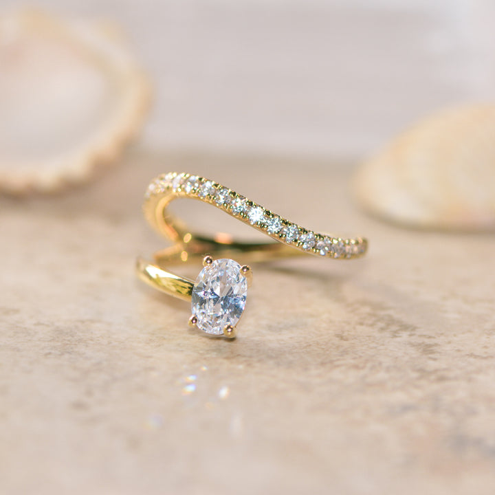 Gold ring with a diamond on a beige background