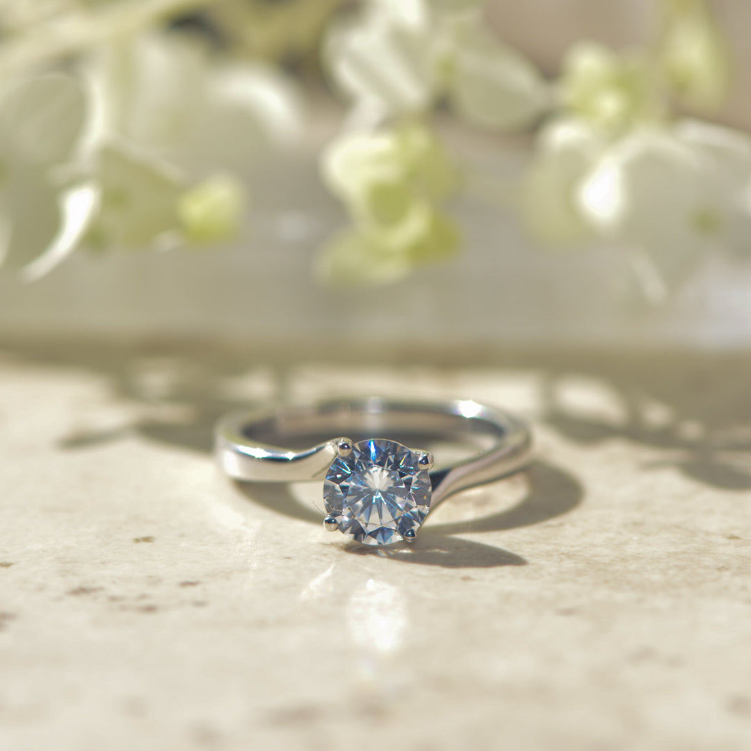 Platinum ring with a round brilliant cut diamond on a light background