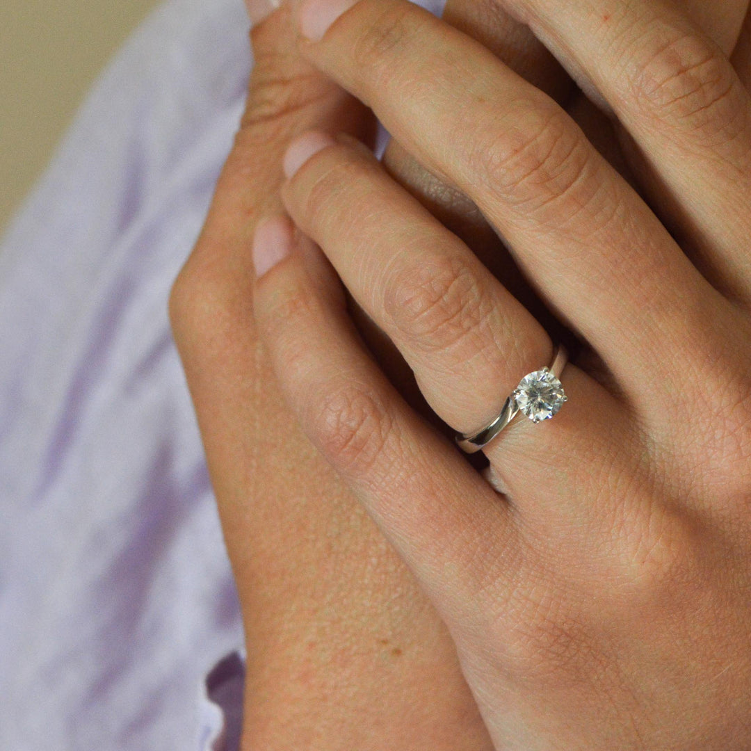 Bird's eye view of a round diamond solitaire ring worn on the hand 