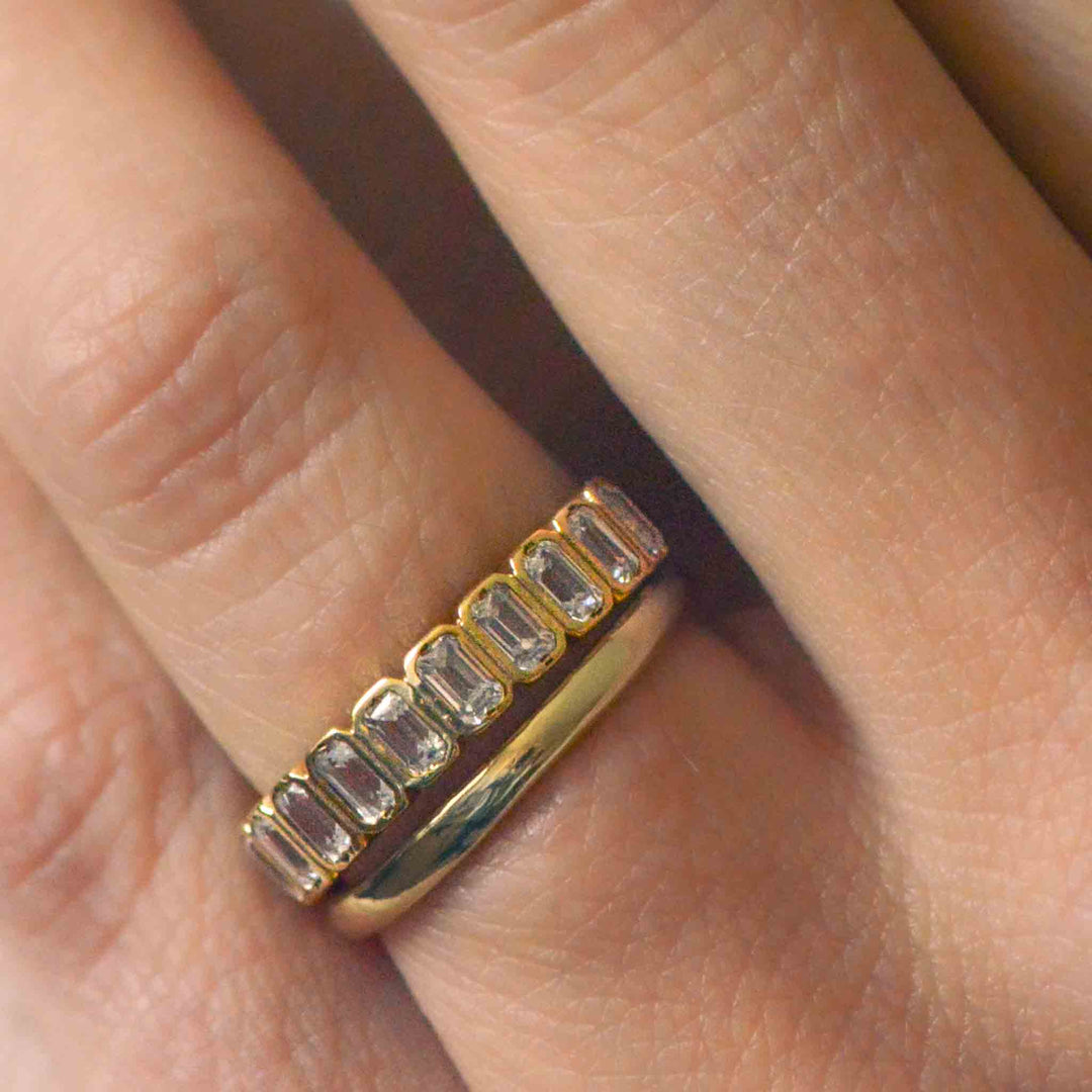 Close up of a stack of wedding rings in diamond and gold on the finger