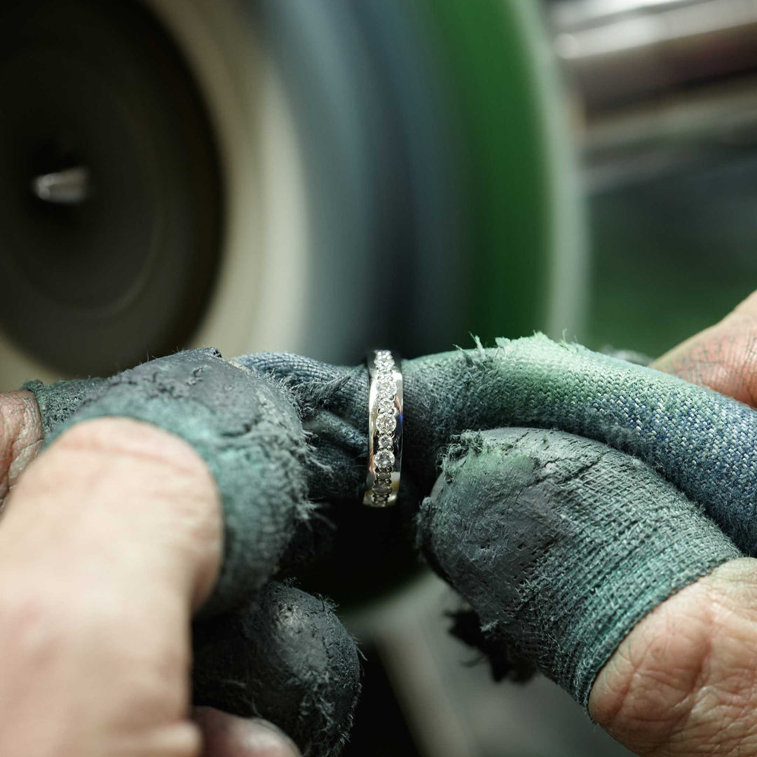 Close-up of a stone setter polishing a bespoke diamond wedding ring