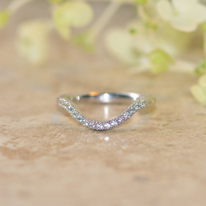 Dipped platinum stacking band set with diamonds on a marble surface