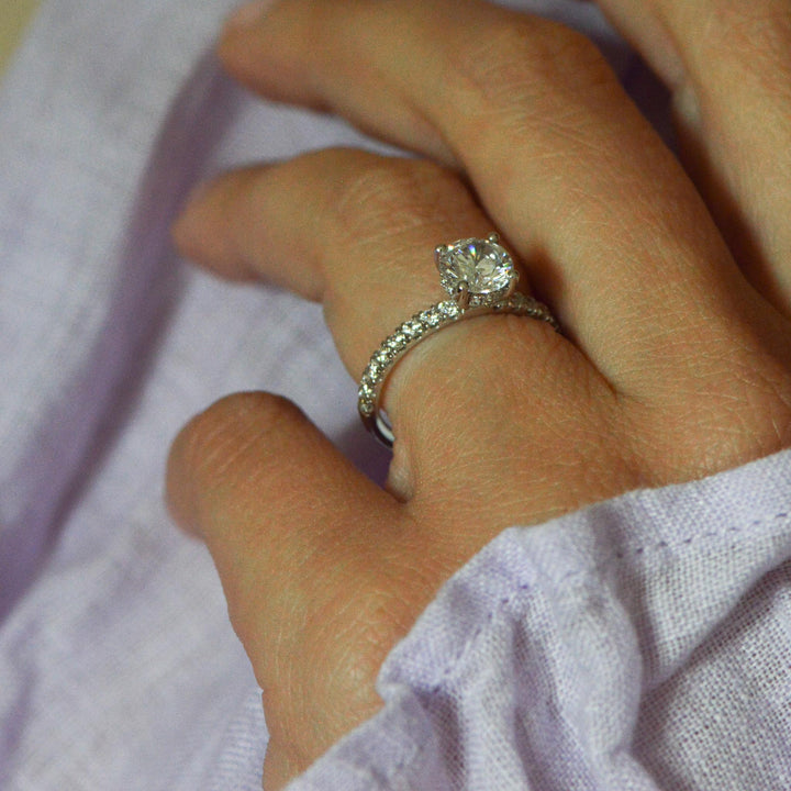 Close up of a shoulder set platinum engagement ring on the hand