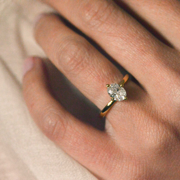 Close up of an oval cut diamond ring on the hand