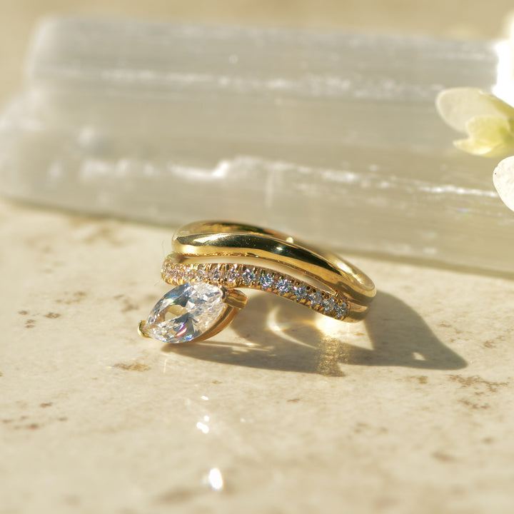 Gold ring with a marquise cut diamond on a textured surface