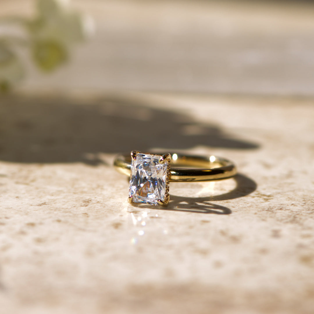 Gold ring with a large radiant diamond on a textured surface