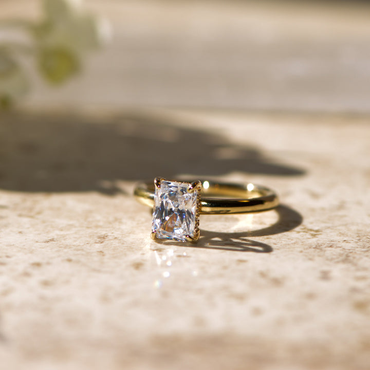 Gold ring with a large radiant diamond on a textured surface