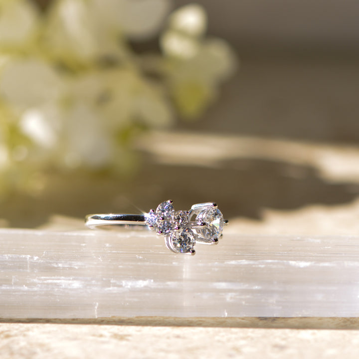 Diamond ring on a light stone surface with a blurred floral background