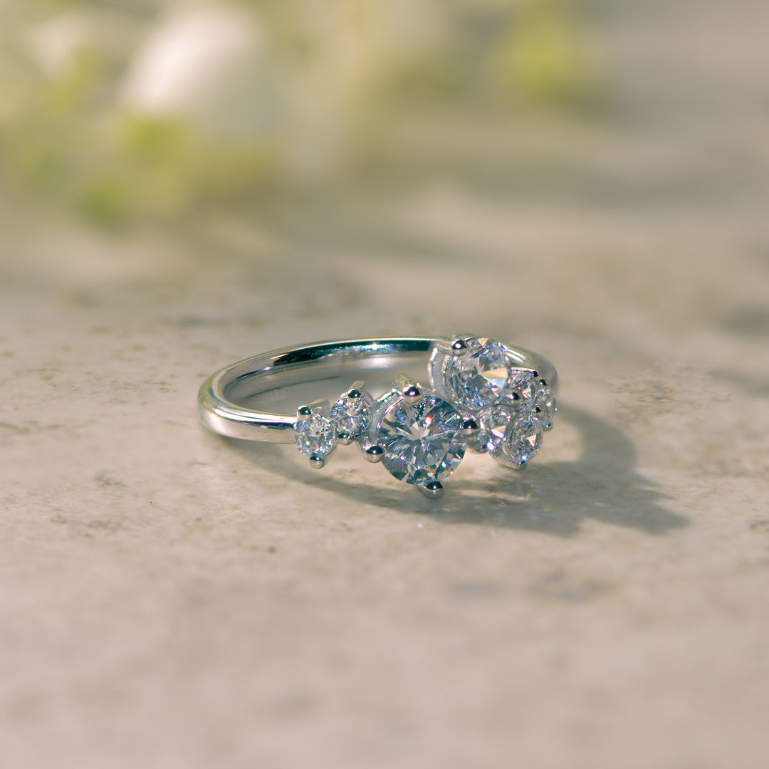 Platinum ring asymmetrically set with round cut diamonds on a textured surface