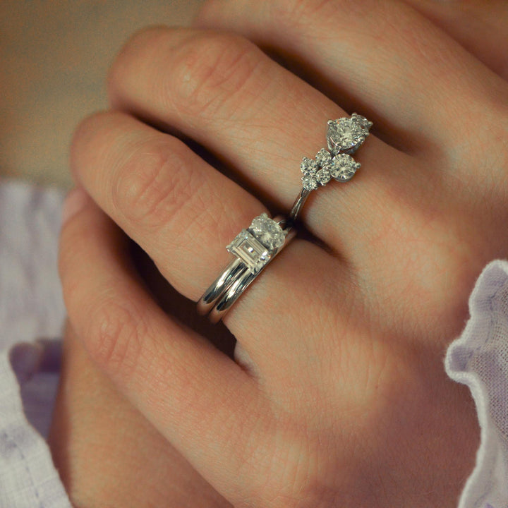Close up of a collection of diamond set platinum rings worn on the hand