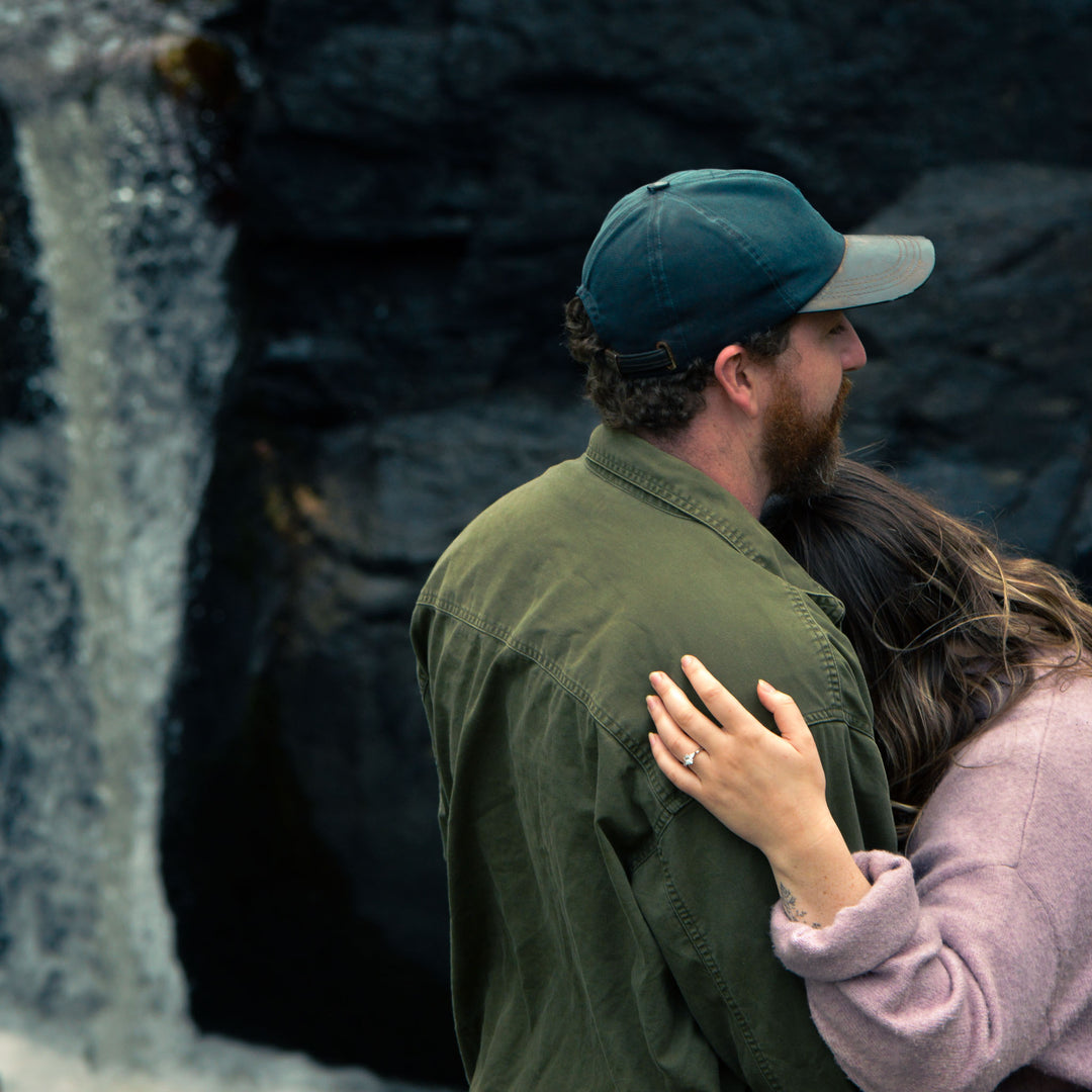 Man and woman embracing in front of a rocky background