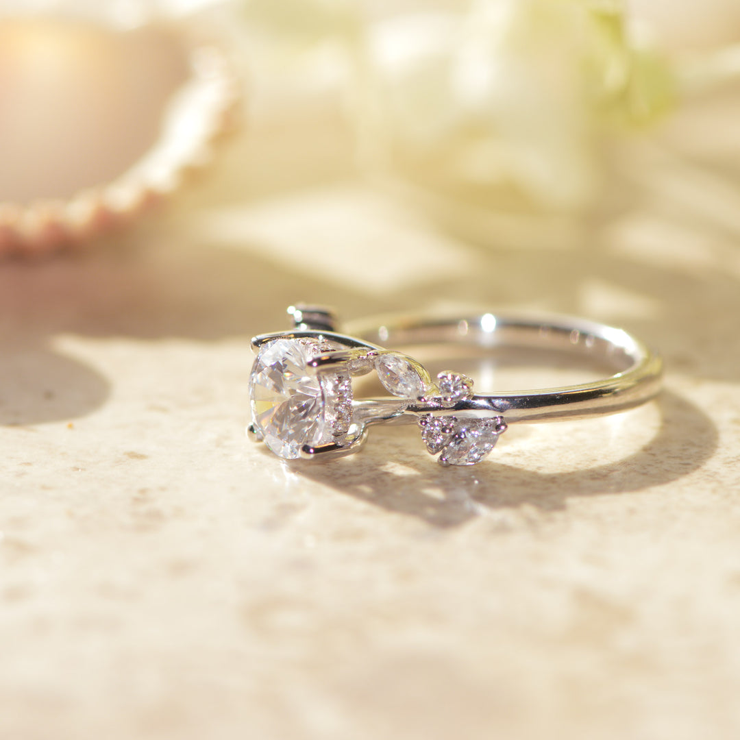 Platinum ring with a large diamond and smaller stones on a soft, blurred background