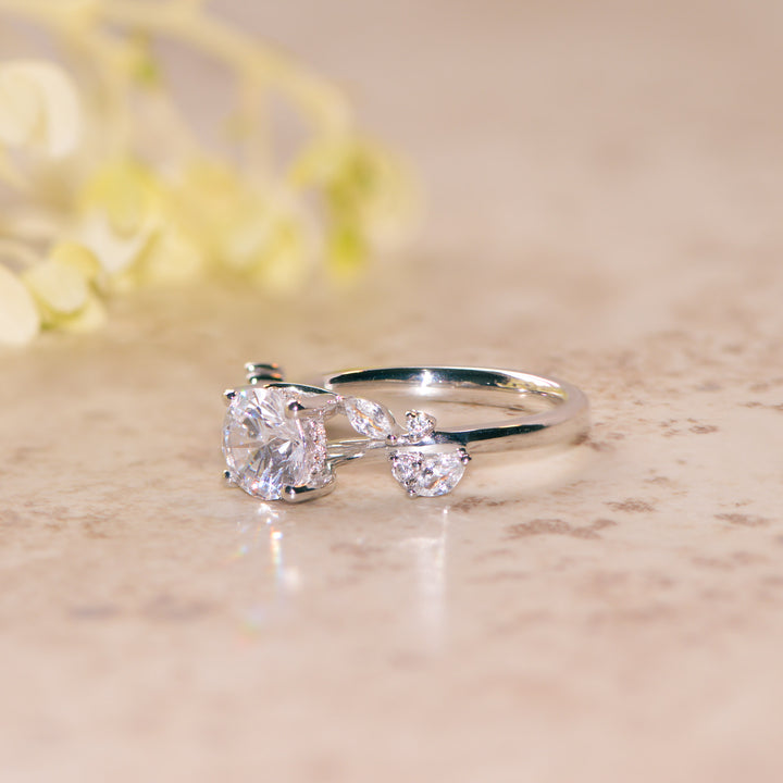Platinum nature inspired ring with round cut diamond on a marble surface