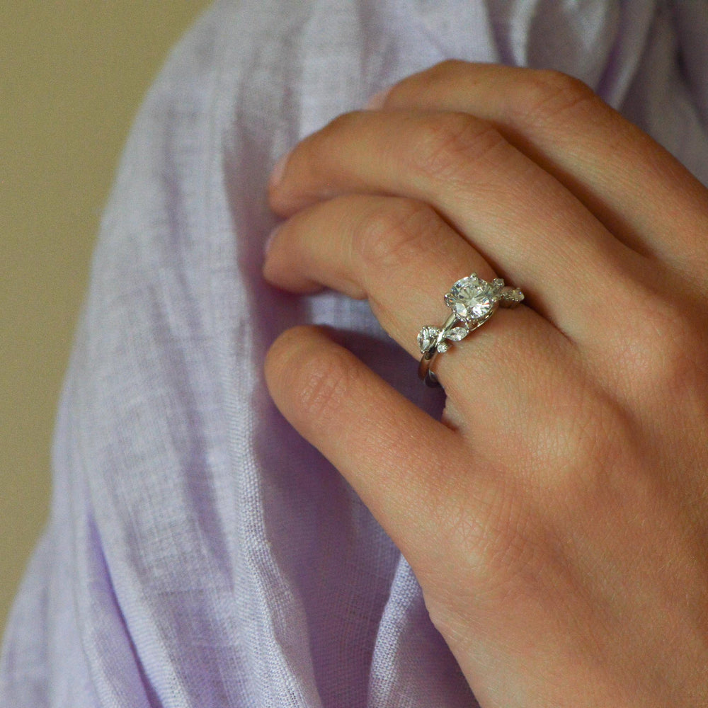 Nature inspired platinum engagement ring worn on the hand set with diamonds 