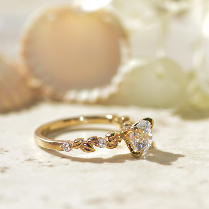 Gold ring with a round cut diamond on a light background