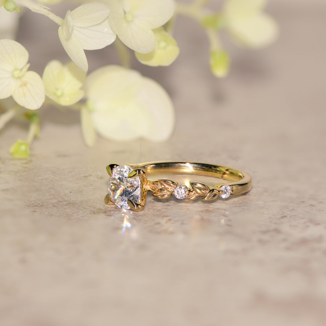 Gold vine ring with a round diamond on a neutral background