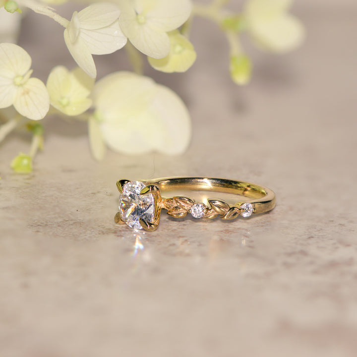 Gold vine ring with a round diamond on a neutral background