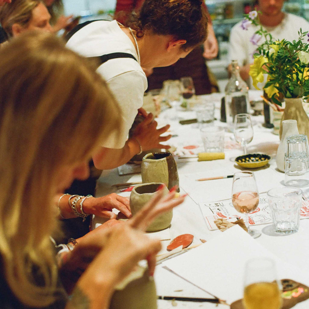 A Cornish creative pottery workshop with people at a table creating handmade Cornish pottery.