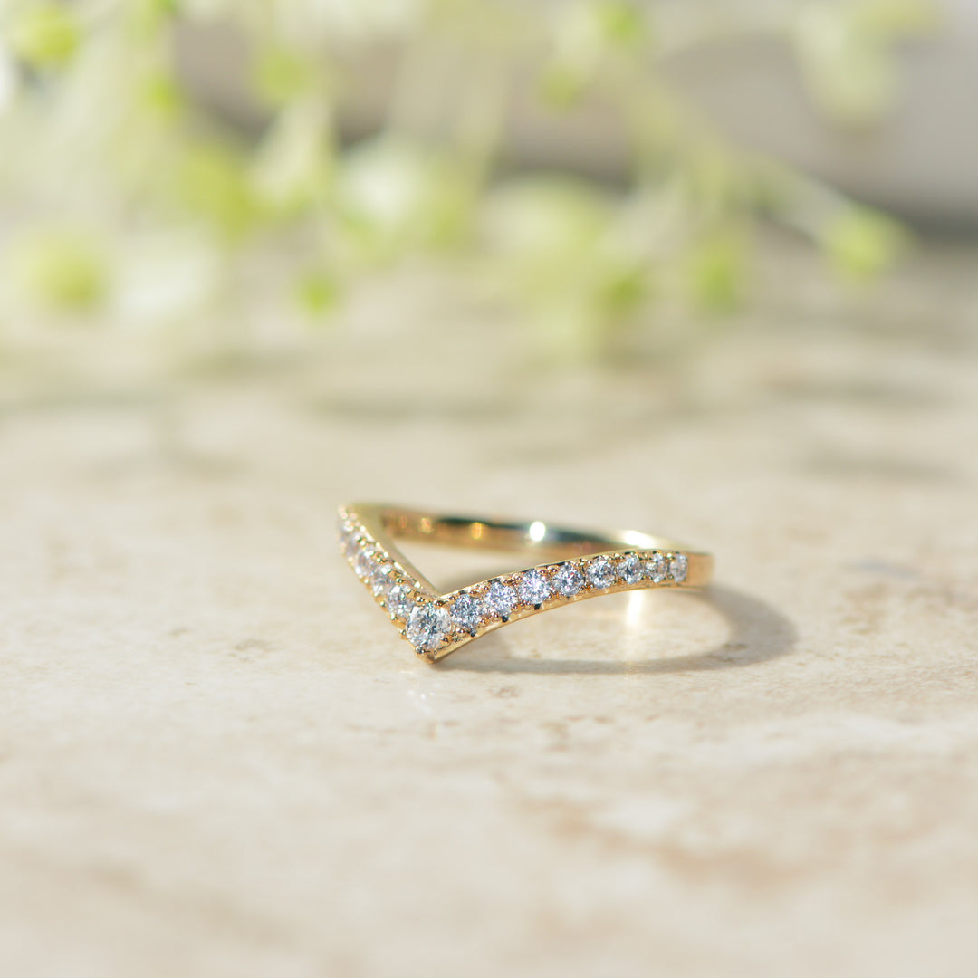 Gold stacking ring with diamonds on a light background