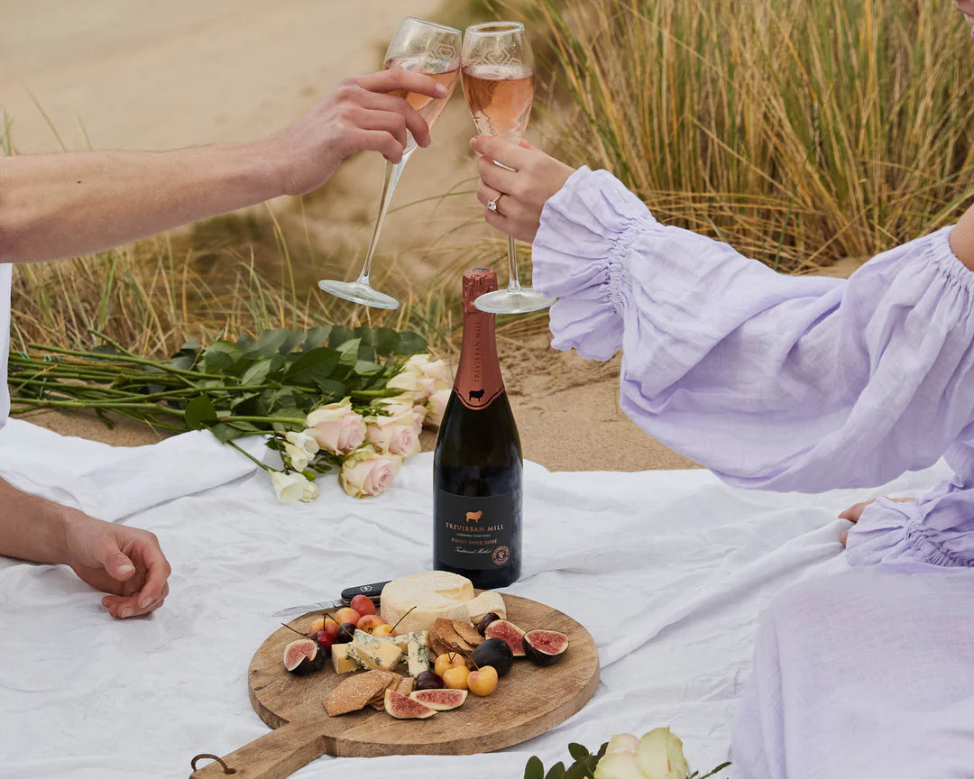 Couple on a Cornish beach celebrating their engagement with the perfect beach  picnic Cornwall 