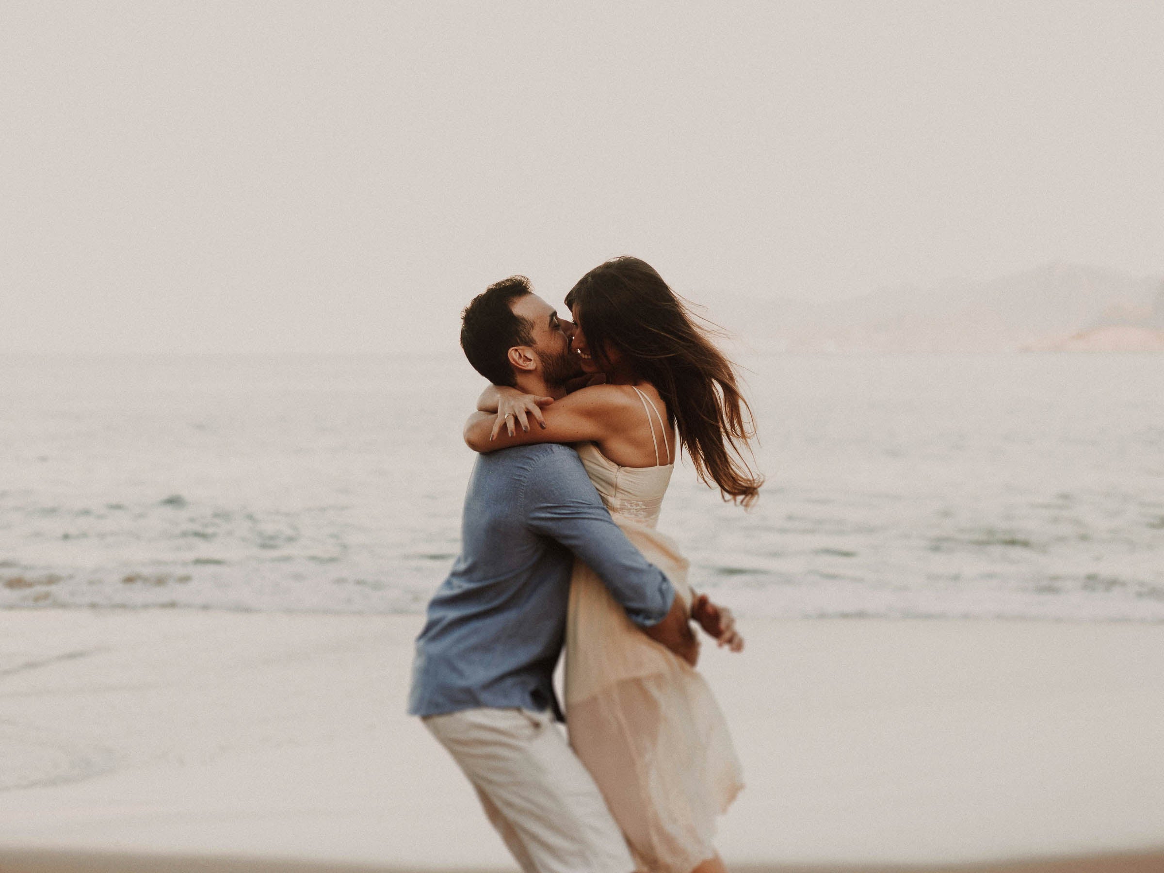 Couple embracing on a beach with a blurred background